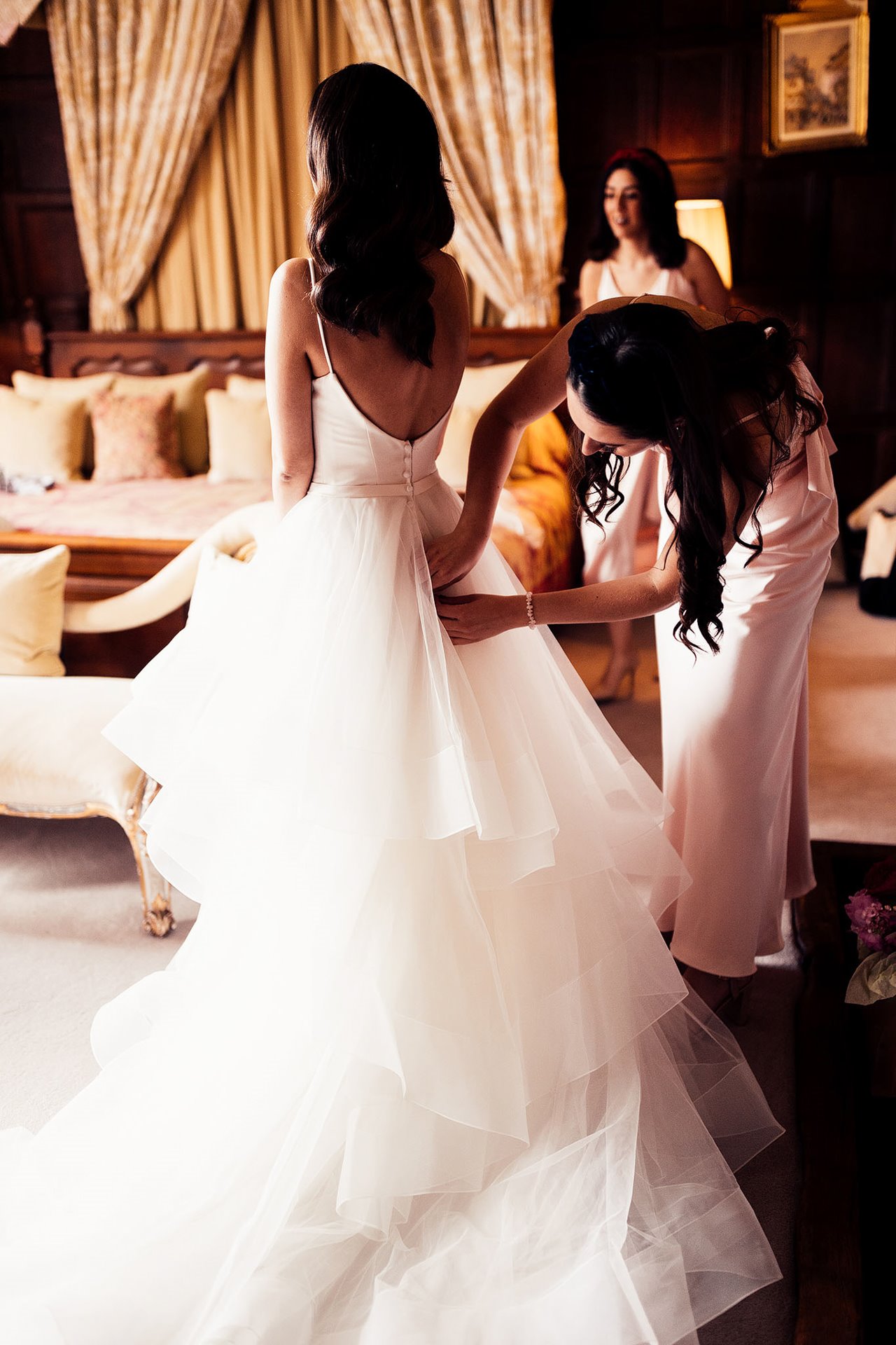 This bride had three wedding dress changes. here she is putting on her ceremony dress with huge skirt