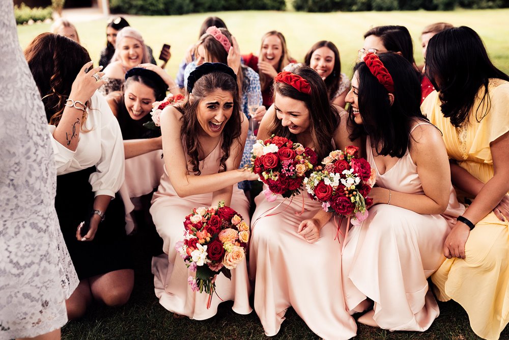 bridesmaids are shocked and laughing get covered in sugar during iranian wedding ceremony at elmore court