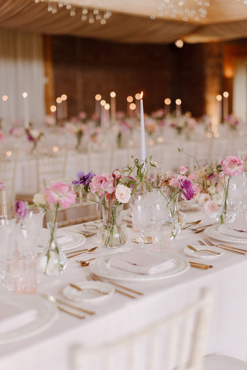 pink and purple flowers in vases at a wedding reception party