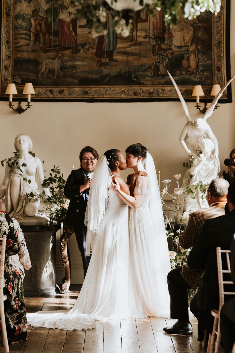 two beautiful brides kissing as they get married at Elmore Court