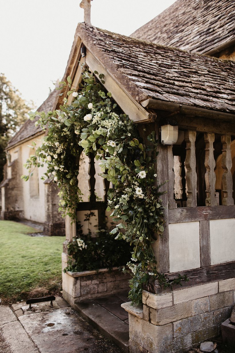 15th century English church porch at Elmore decorated with foliage and flowers for a wedding