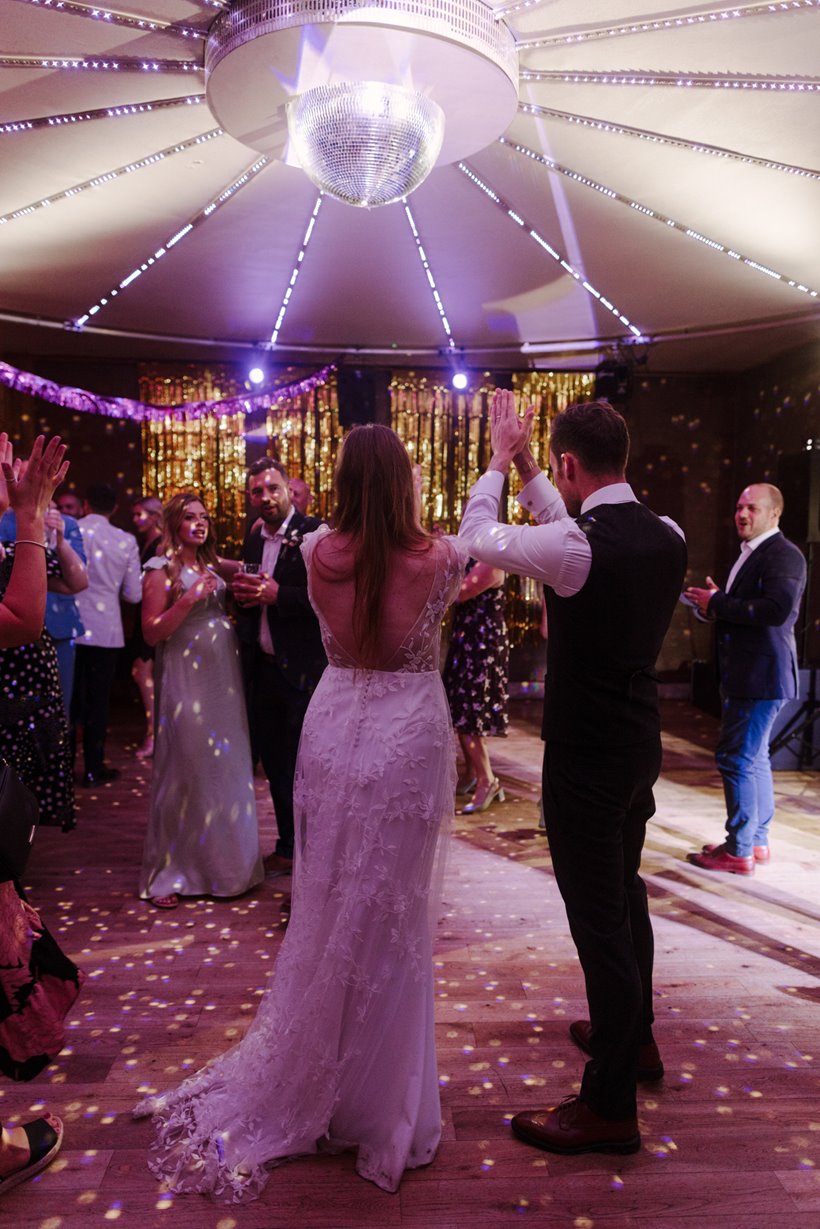 Party wedding with pretty lighting on dance floor guests dancing having fun