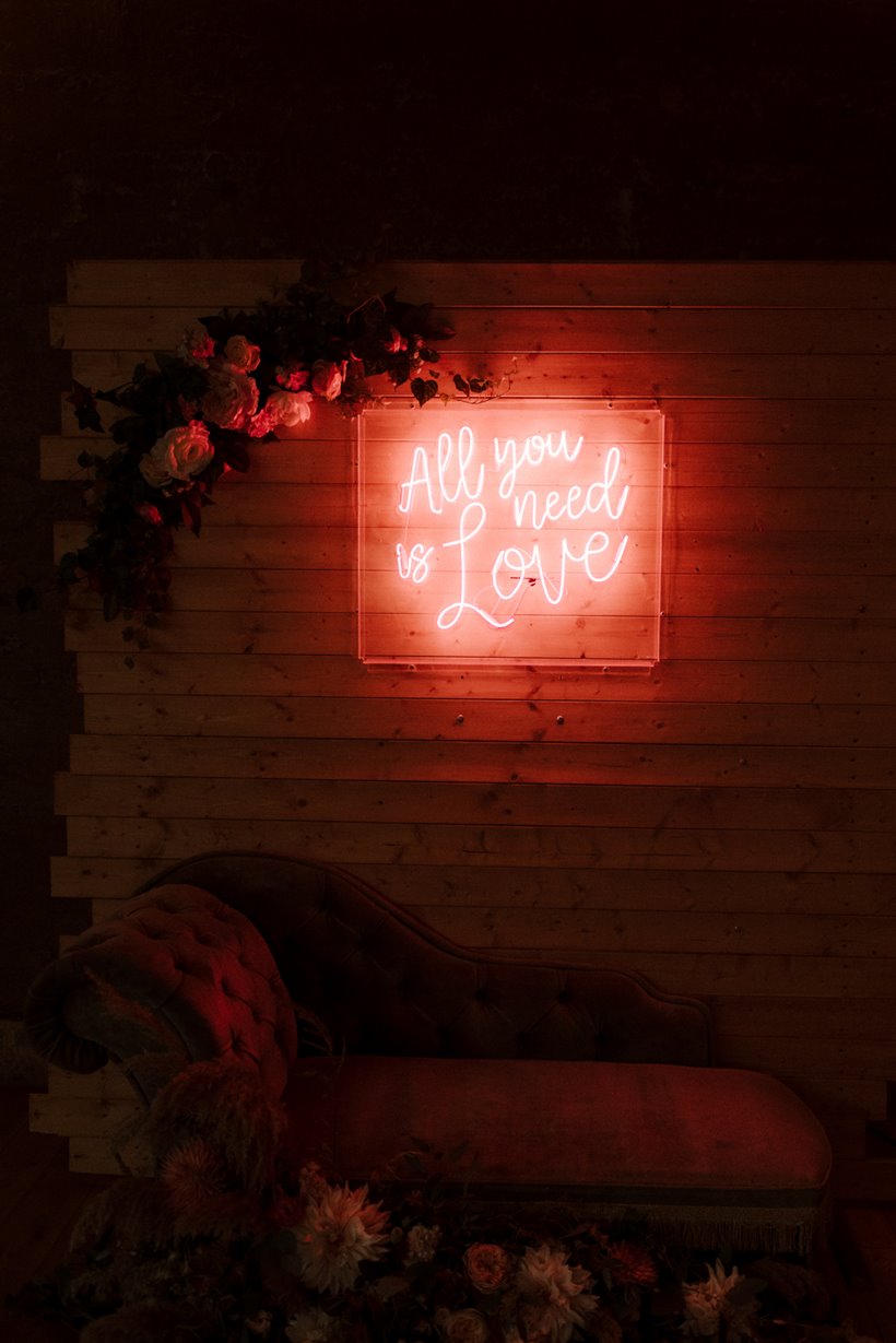 neon wedding sign all you need is love for boho september wedding with luxe details at sustainable wedding venue in cotswolds