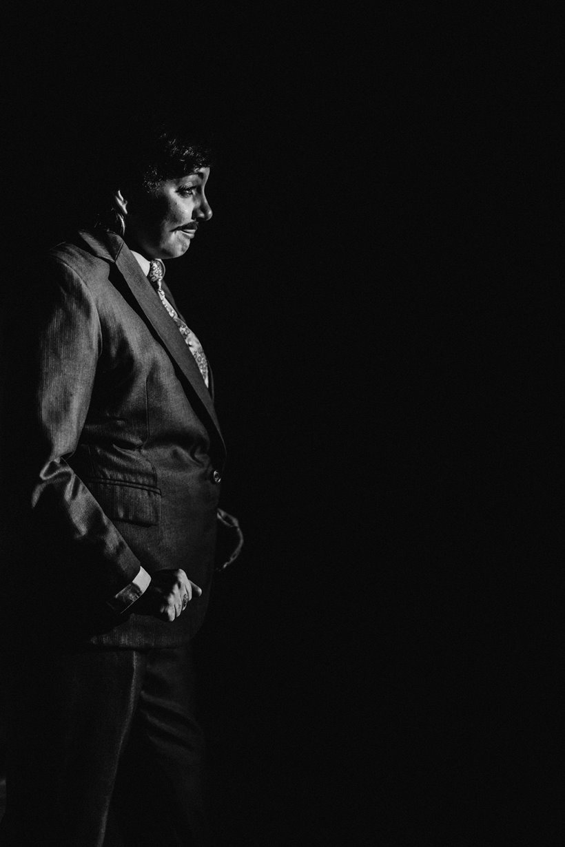 Drag king Jess love in black and white performs a routine in a suit and moustache at cabaret dinner at elmore court