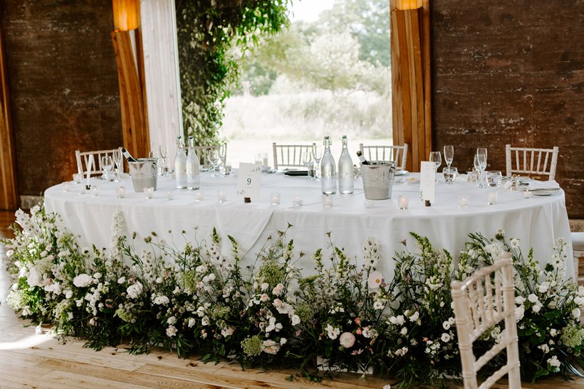 wild meadow style wedding flowers around the bottom of the top table at a wild wedding at elmore court