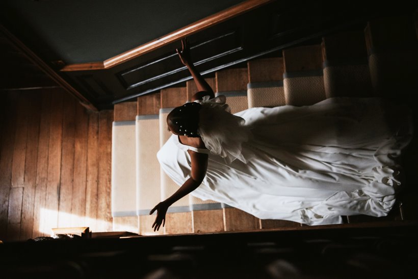 bride in white dress walking down the stairs of a stately home in Gloucestershire 