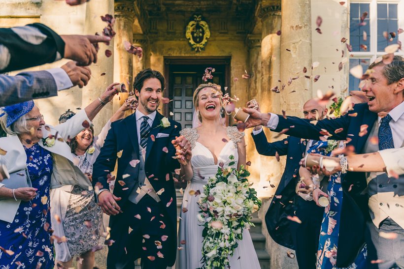 Micro wedding couple covered in confetti surrounded by friends and family outside at elmore court covid safe wedding venue