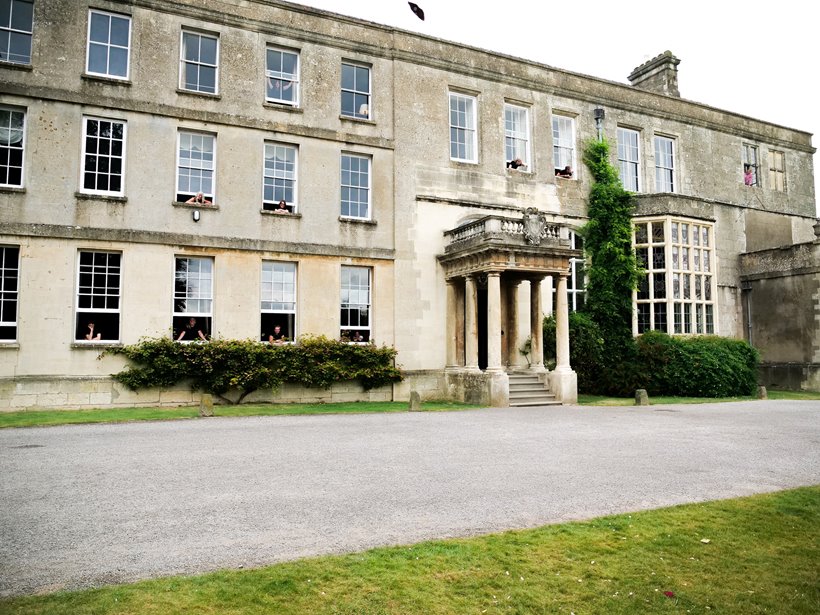 all of the housekeeping team looking out the windows of mansion house elmore court in the cotswolds