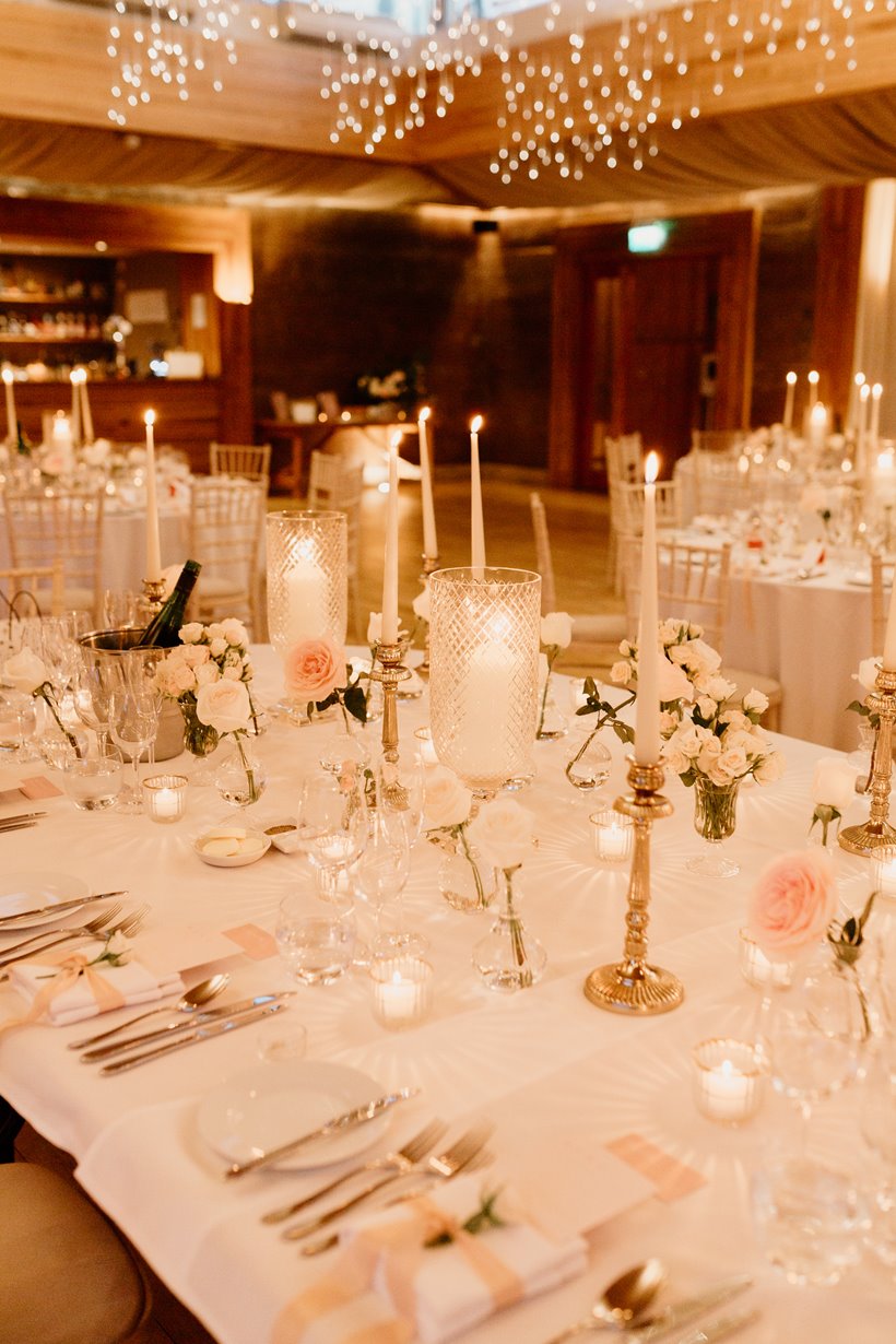 elegant table setting at a wedding reception at Elmore Court, with tables dressed in white flowers with touches of pastel pink