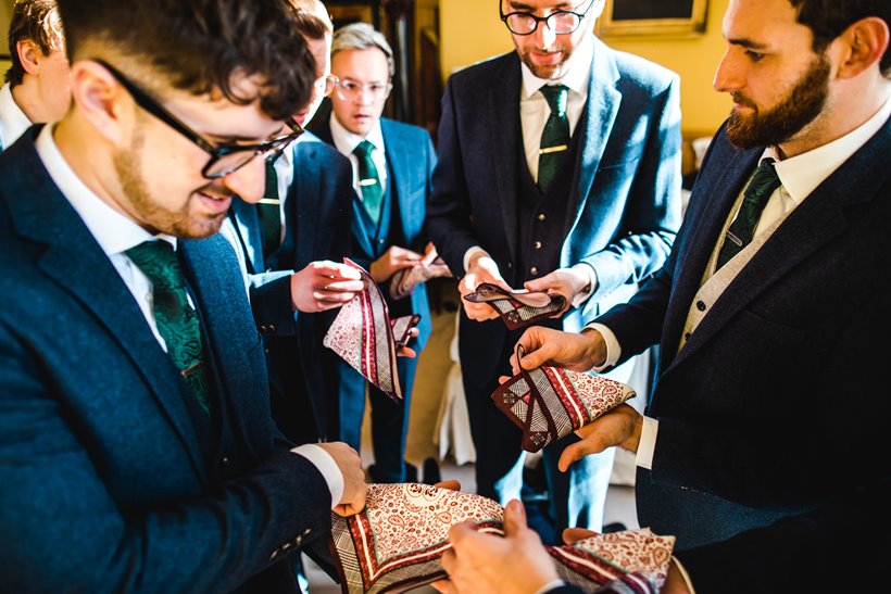 Groomsmen trying to fold pocket squares 