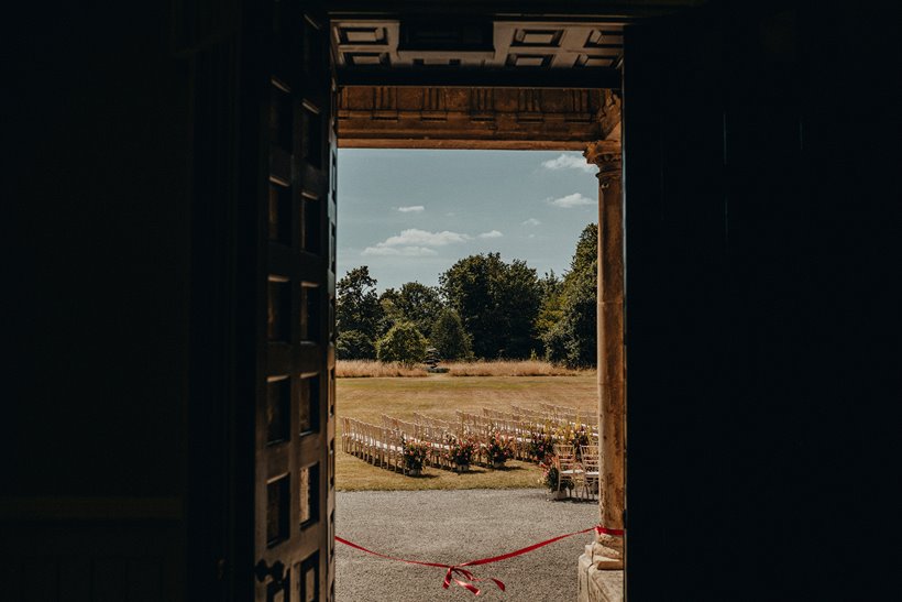 Ribbon tied across door to outdoor wedding ceremony in a beautiful manor house in the countryside