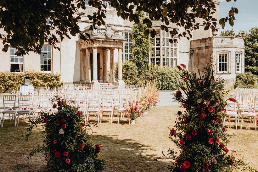 outdoor wedding ceremony in front of stately home wedding venue in the cotswolds