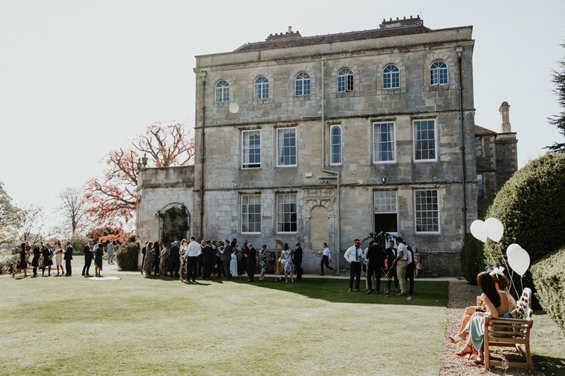 Wedding guests with balloons on the lawn at Elmore Court