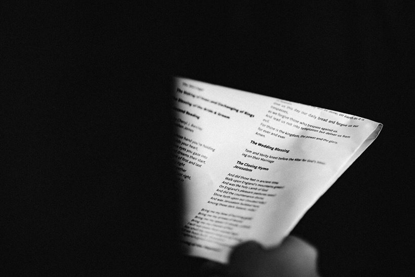 Black and white photo of wedding hymns held in hand